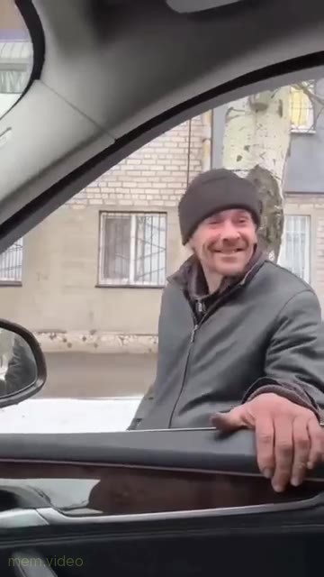 Кадр: Мужчина в шапке держится за дверь авто и танцует