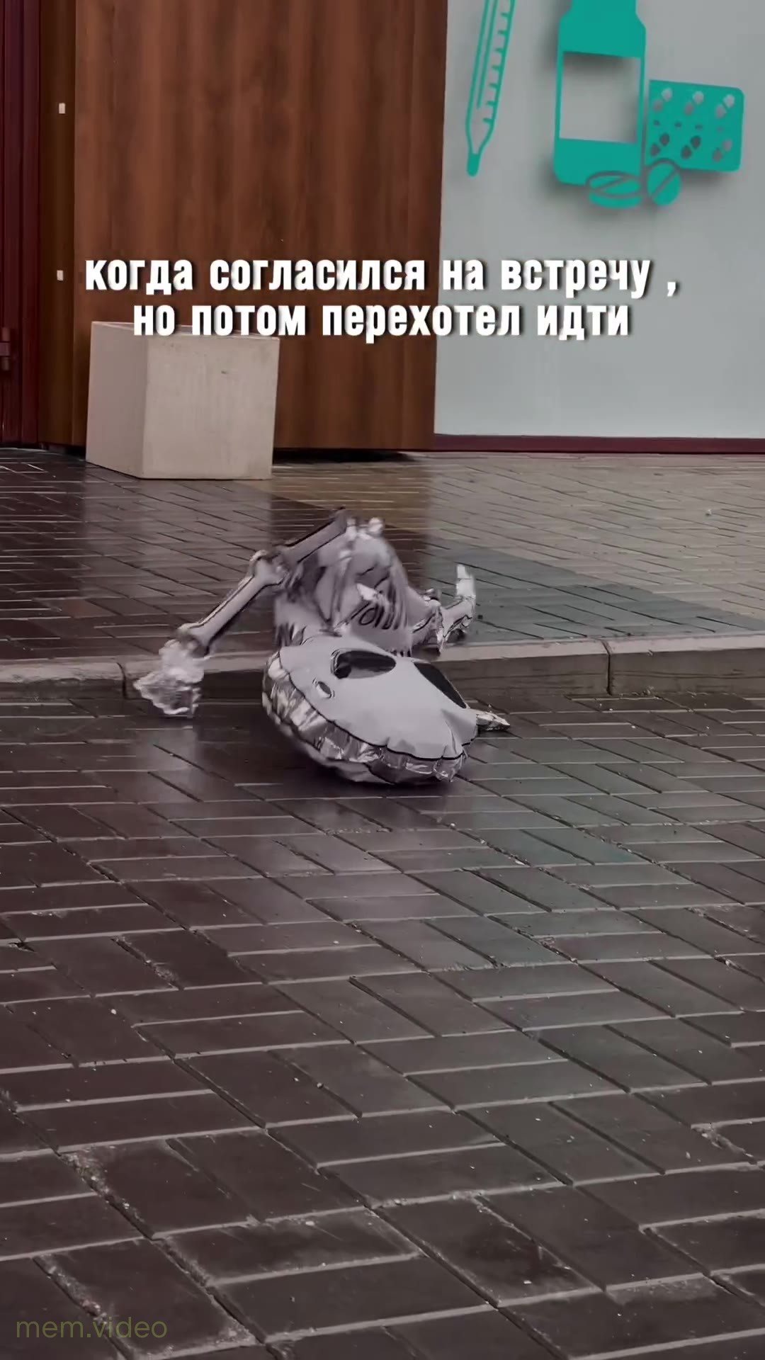 Кадр: Сдутый шарик-скелет перекатывается по асфальту