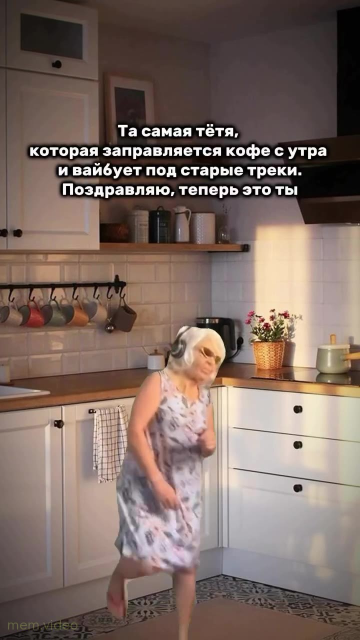 Кадр: Бабушка в наушниках и очках танцует на кухне