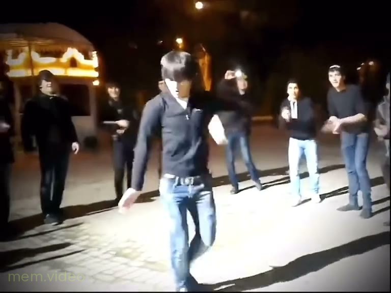 Кадр: Мужчины танцуют лезгинку в кругу зрителей на улице