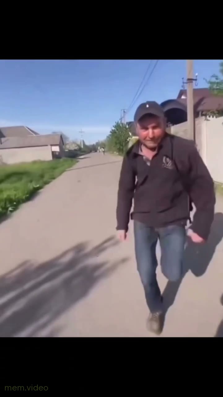 Кадр: Мужчина в кепке бежит по сельской дороге
