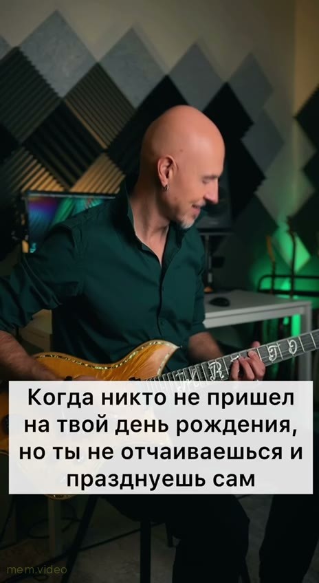 Кадр: Мужчина в наушниках поет и играет на гитаре