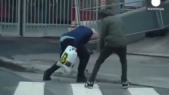 Кадр: Мужчина в синей куртке идет против шквального ветра