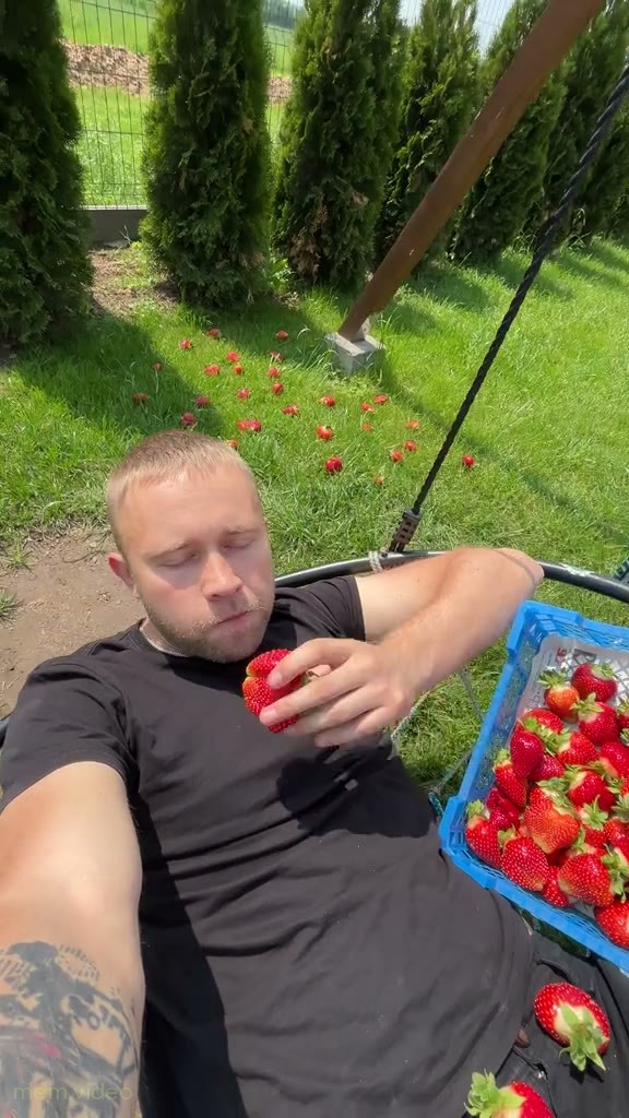 Кадр: Мужчина ест клубнику на качелях