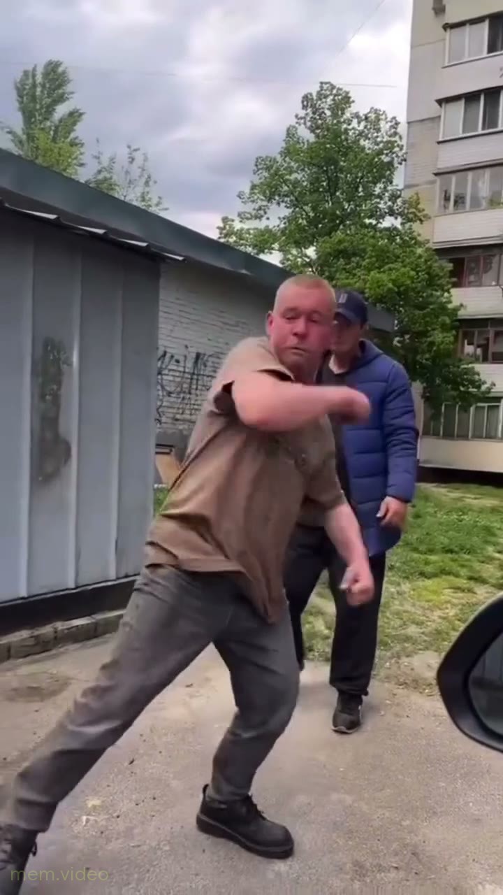 Кадр: Три мужчины танцуют на улице у гаражей