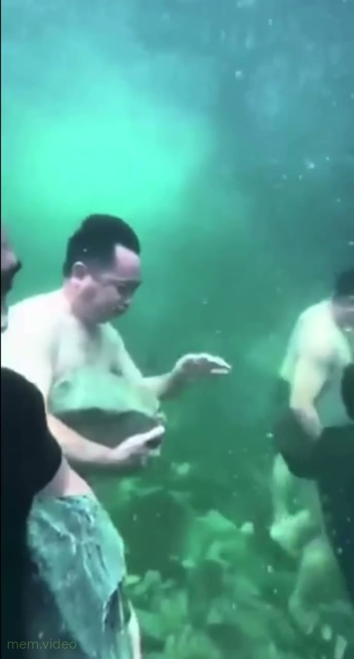 Кадр: Мужчины бегают под водой с камнями