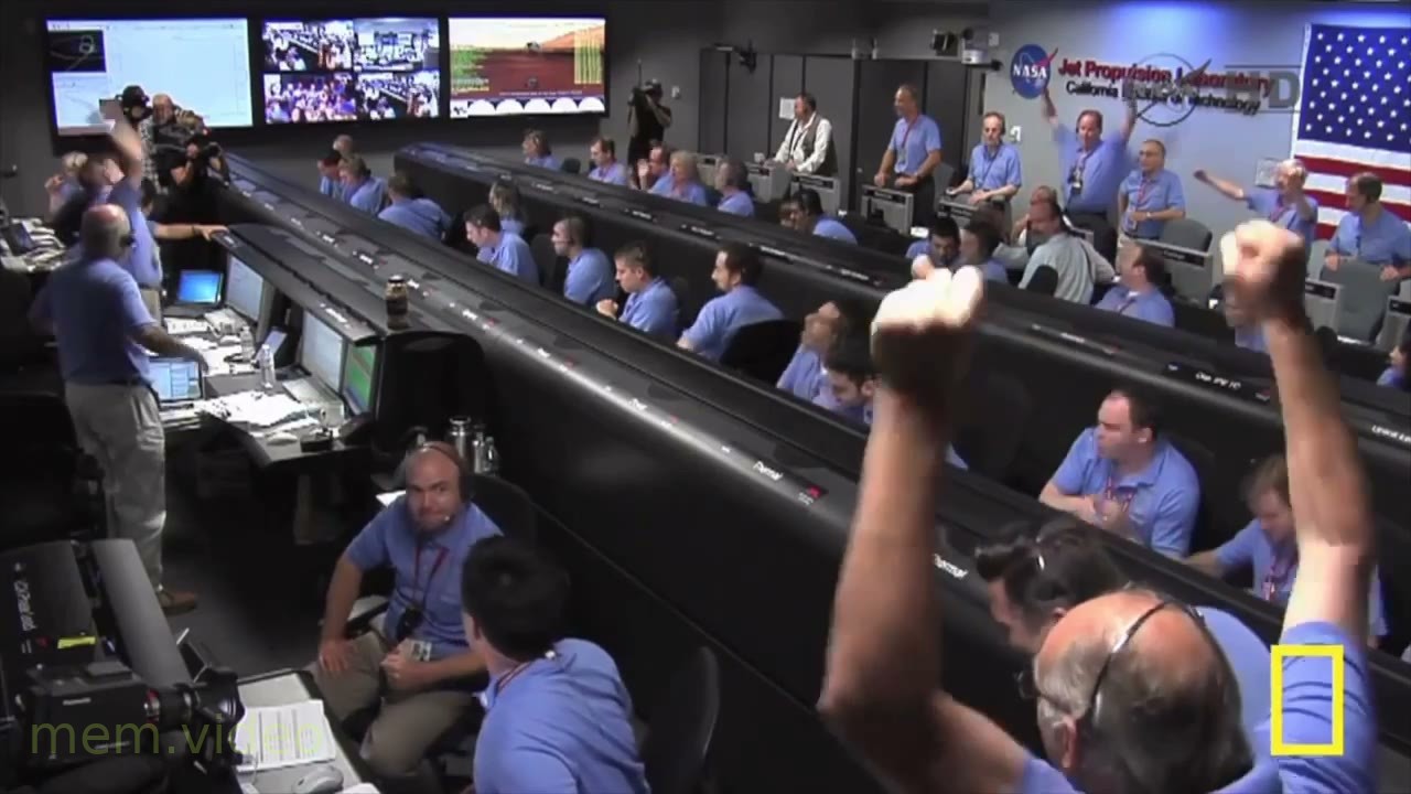 Кадр: Работники NASA радуются и обнимаются в центре управления